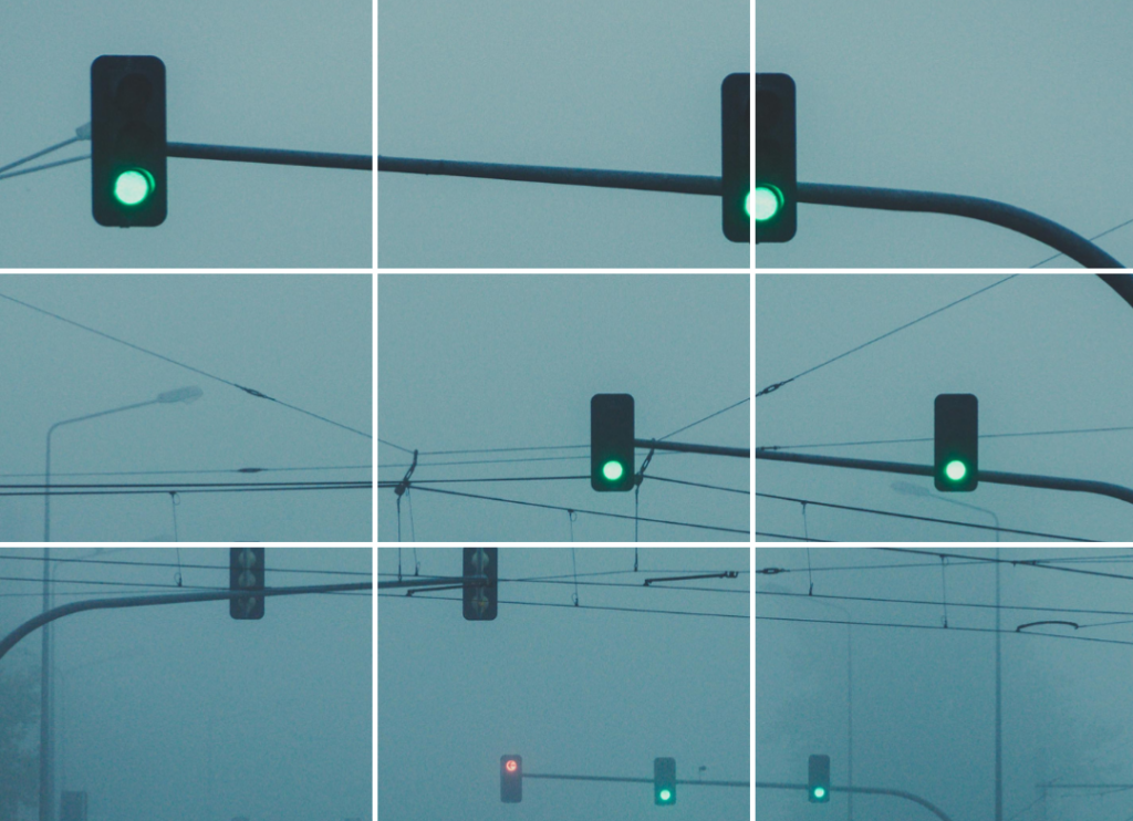 Ein trübes Bild mit vielen Ampeln an einer Kreuzung. Das Bild ist in mehrere Felder unterteilt, so wie in einem CAPTCHA